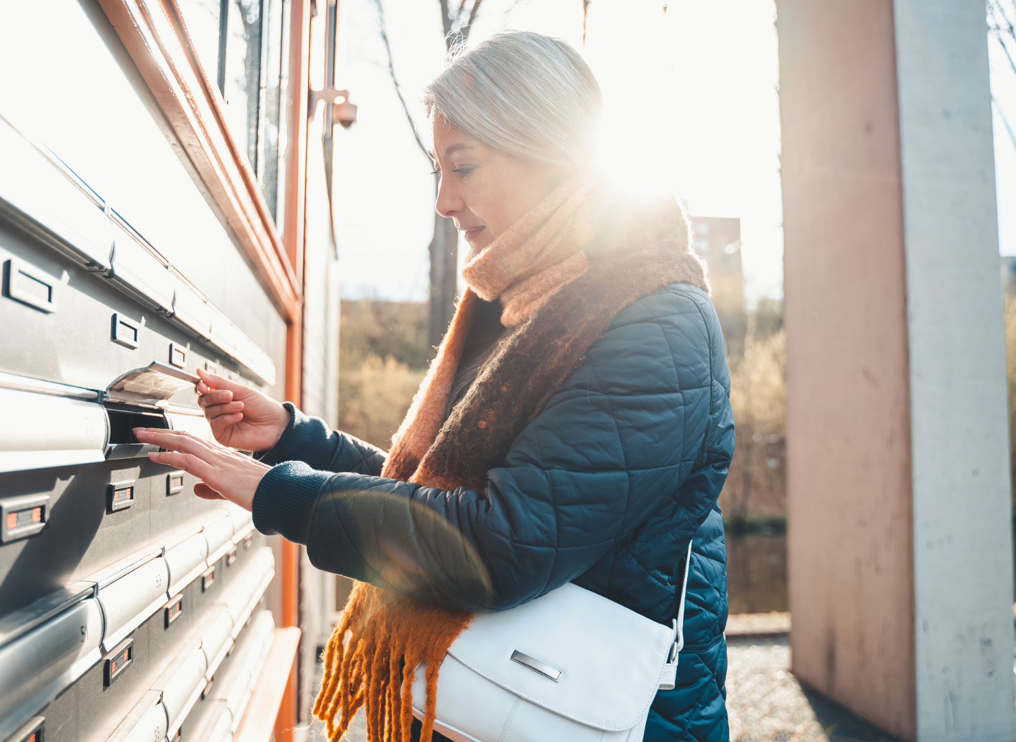 A woman checking her mailbox for Every Door Direct Mail (EDDM).
