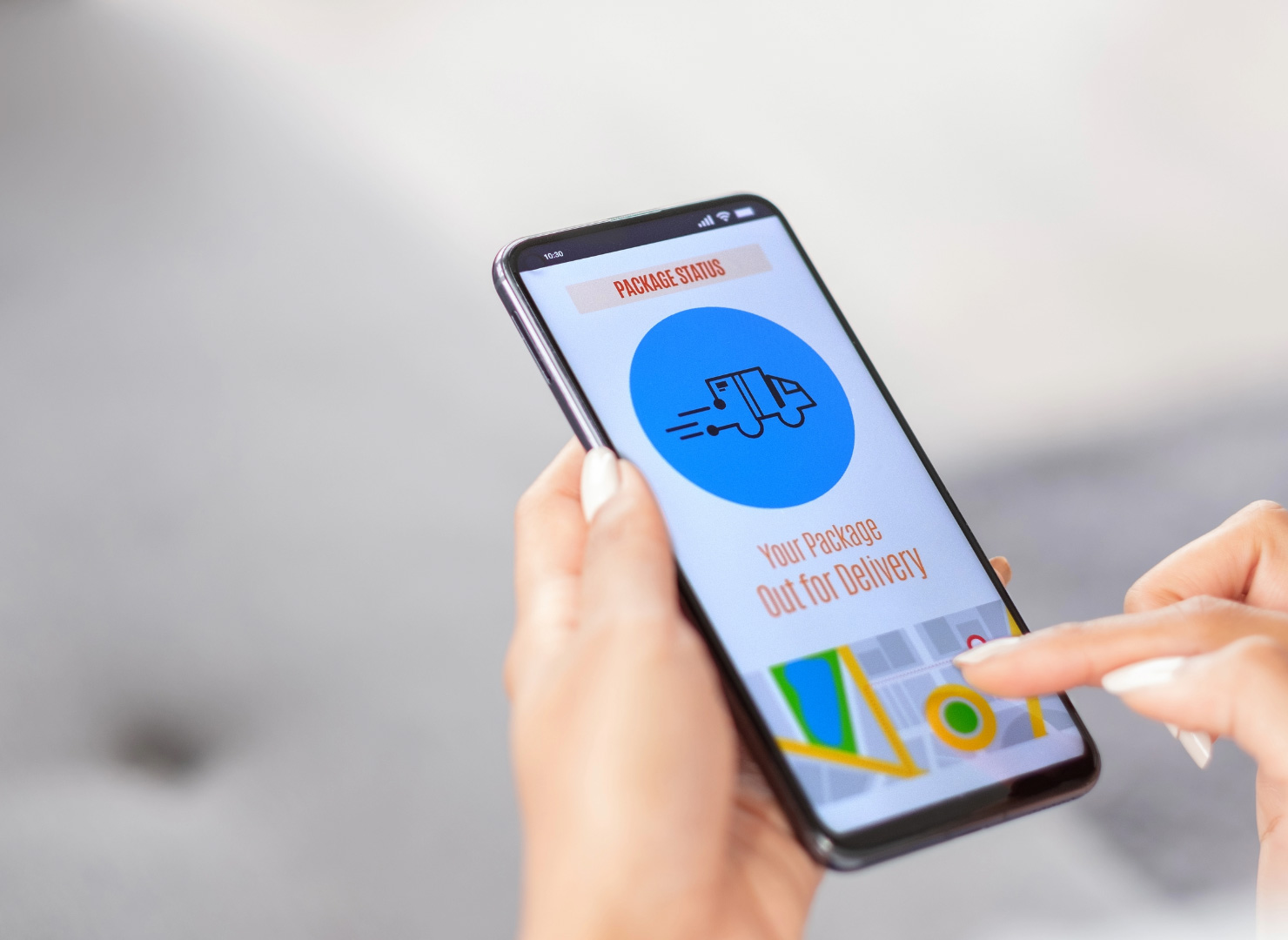 A closeup of a smartphone displaying the status of a package being tracked.